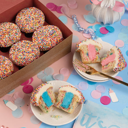 gender reveal box of sprinkle cupcakes with pink and blue vanilla buttercream filling