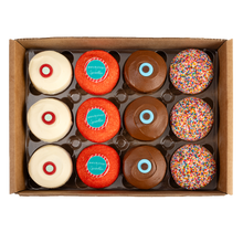 Load image into Gallery viewer, Top view of Patchology Candy Apple Assorted dozen with 3 red velvet, 3 candy apple, 3 dark chocolate, and 3 sprinkle cupcakes. not-bg
