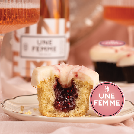 half of kir royale cupcake with raspberry chambord jam core, cream cheese frosting marbled with raspberry chambord jam and an une femme decoration