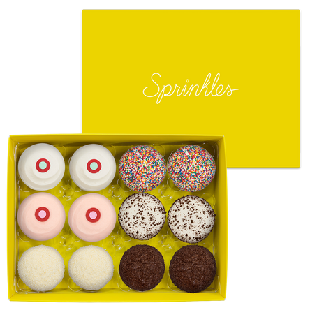 Assorted Dozen Yellow Box includes 2 Red Velvet, 2 Strawberry, 2 Vanilla, 2 Sprinkles, 2 Black & White, and 2 Dark Chocolate cupcakes.