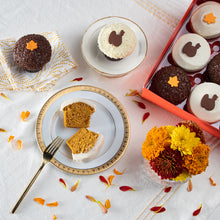 Load image into Gallery viewer, table set with our gratitude dozen box including pumpkin, dark chocolate, red velvet and vanilla with Thanksgiving themed decorations not-bg
