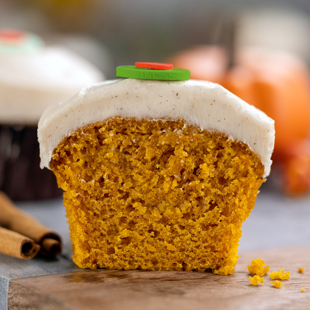 half of a pumpkin cupcake with cinnamon cream cheese frosting. not-bg