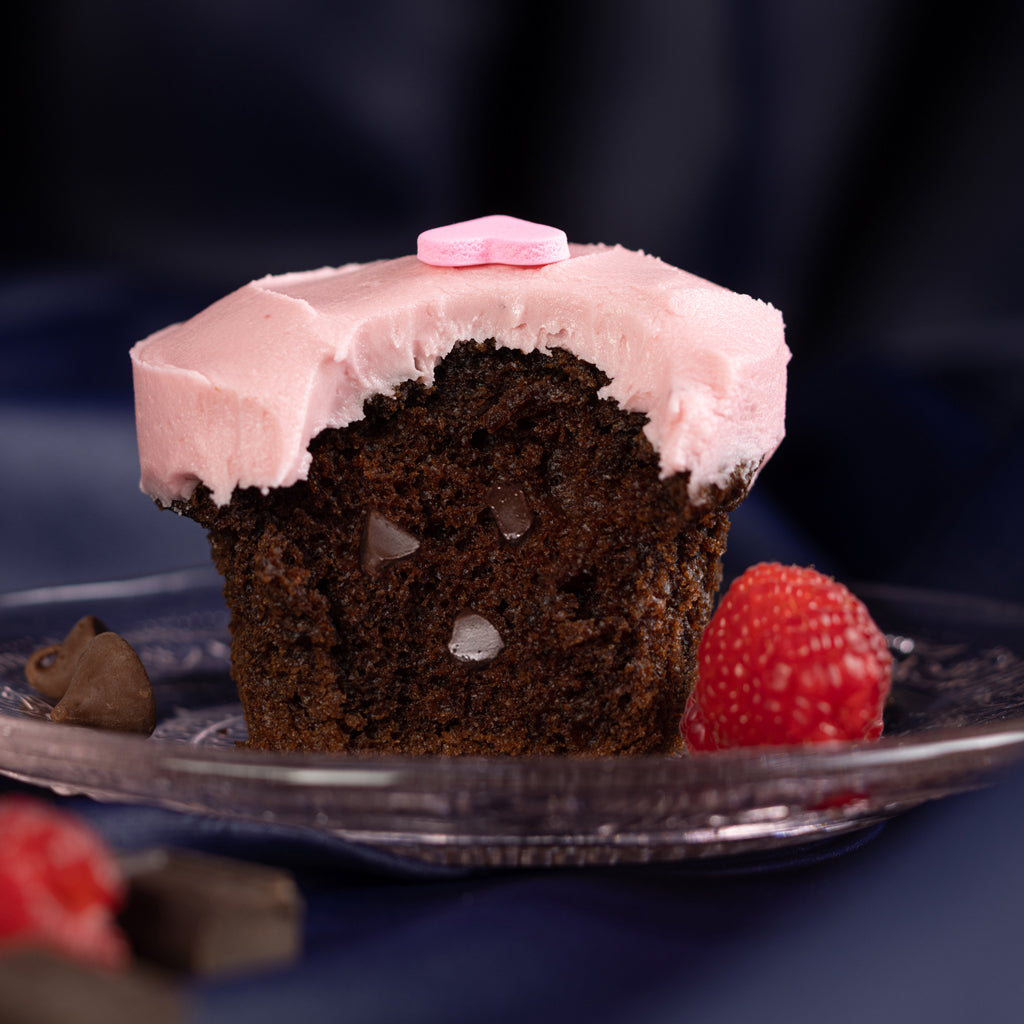 plated raspberry chocolate chip cupcake with chocolate chip studded Belgian dark chocolate cake topped with luscious raspberry frosting