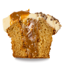Load image into Gallery viewer, half of a sticky toffee cupcake with caramel filling and date infused buttercream frosting topped with crushed chocolate toffee crumble and caramel sauce not-bg
