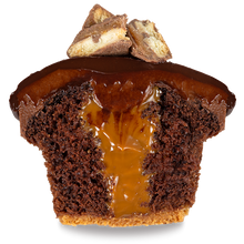 Load image into Gallery viewer, half of a twix cupcake with a cookie crust lined chocolate cake, caramel filling, chocolate cream cheese frosting, a ladle of ganache, and topped with mini twix decorations not-bg
